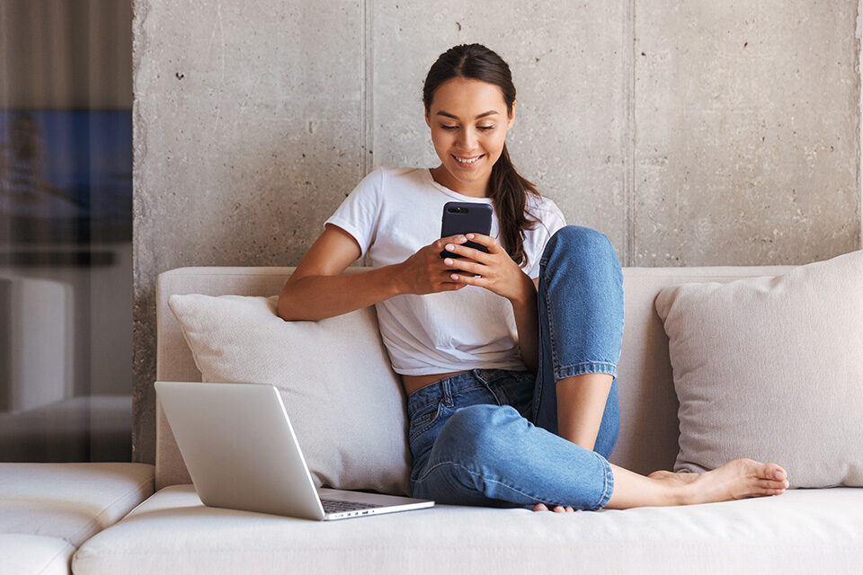 Frau am Handy auf Sofa - Mobile